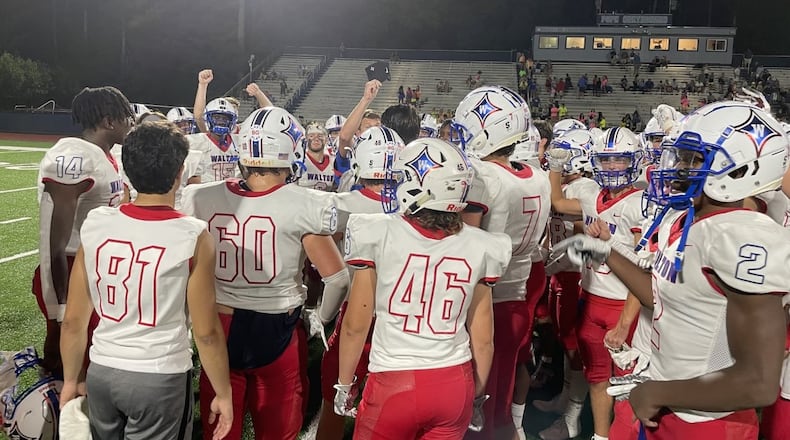 Walton players surround their coaches for a postgame talk after defeating Pope 34-7 in Marietta on Aug. 27, 2021. (Photo by Chip Saye)