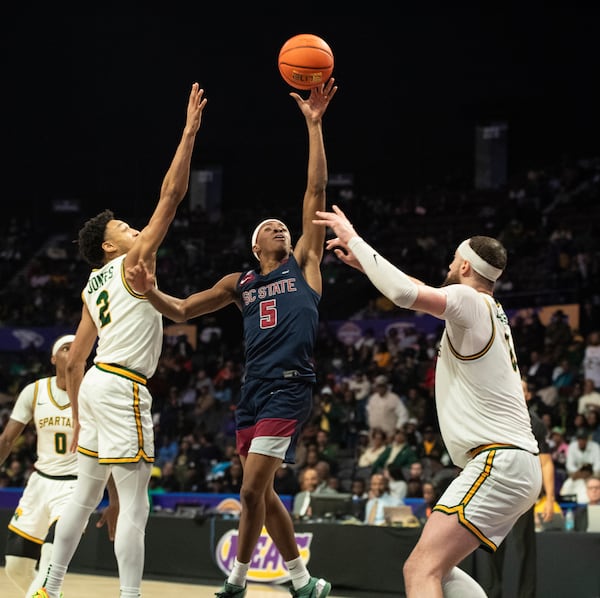 South Carolina State guard Jayden Johnson (5) attempts a one handed floater between Norfolk State defenders Terrance Jones (2) and Tyrel Bladen (8) during the second half of an NCAA college basketball game in the championship of the Mid-Eastern Athletic Conference tournament, Saturday, March 15, 2025, in Norfolk, Va. (AP Photo/Mike Caudill)