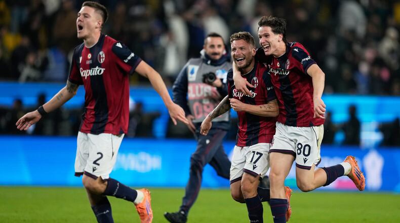 Bologna's Ciro Immobile, center, celebrates with teammates Emil Holm, left, and Giovanni Fabbian after scoring the winning goal during a penalty shoot out at the end of an Italian Super Cup semi-final soccer match between Bologna and Inter Milan in Riyadh, Saudi Arabia, Friday, Dec. 19, 2025. (AP Photo/Altaf Qadri)
