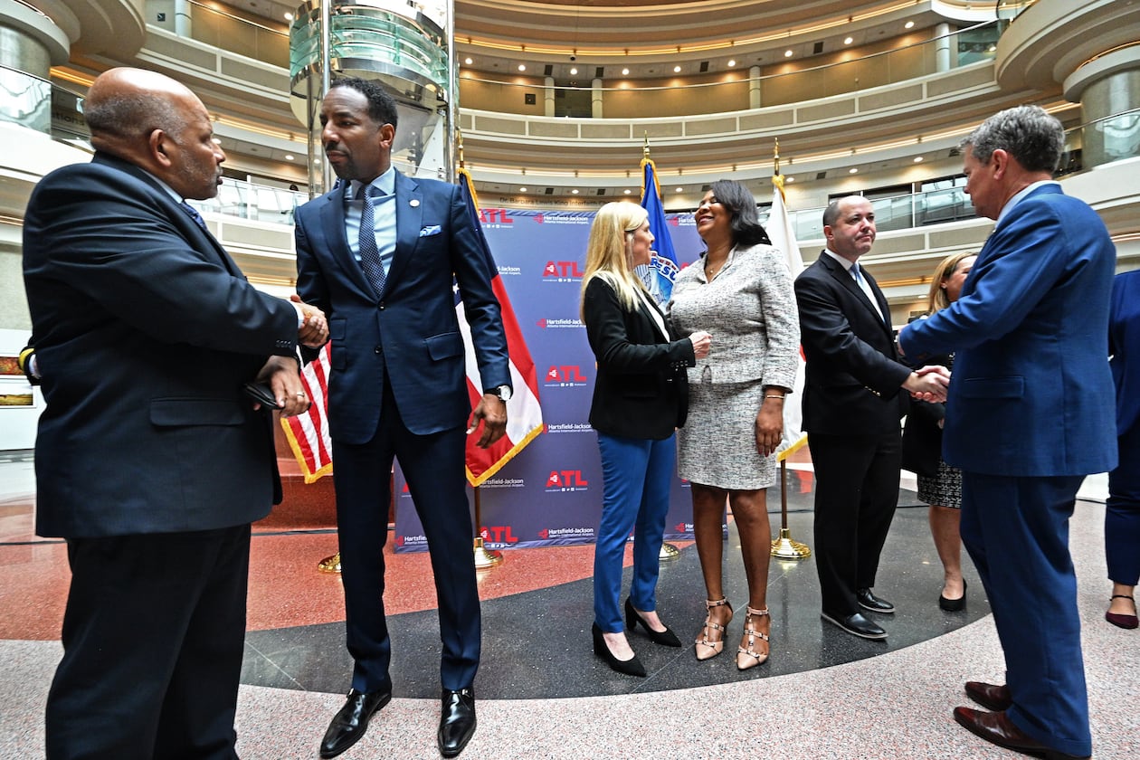 Atlanta Mayor Andre Dickens (second from left) and Governor Brian Kemp (right) greet guests after a human trafficking prevention press conference at Hartsfield-Jackson Atlanta International Airport on Jan. 31, 2023. (Hyosub Shin/AJC)
