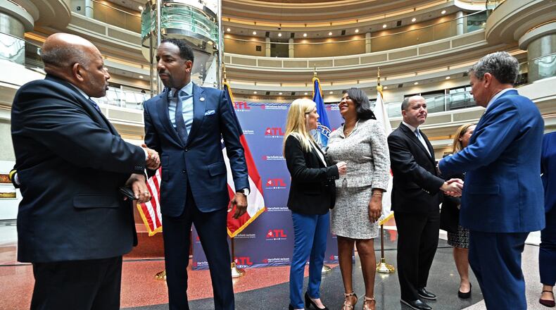 Atlanta Mayor Andre Dickens (second from left) and Governor Brian Kemp (right) greet guests after a human trafficking prevention press conference at Hartsfield-Jackson Atlanta International Airport on Jan. 31, 2023. (Hyosub Shin/AJC)