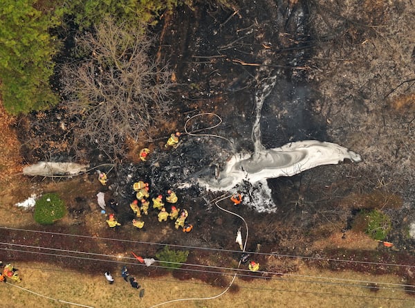 Firefighters inspect the wreckage of a crashed firefighting helicopter at a mountain in Uiseong, South Korea, Wednesday, March 26, 2025. (Son Hyung-joo/Yonhap via AP)