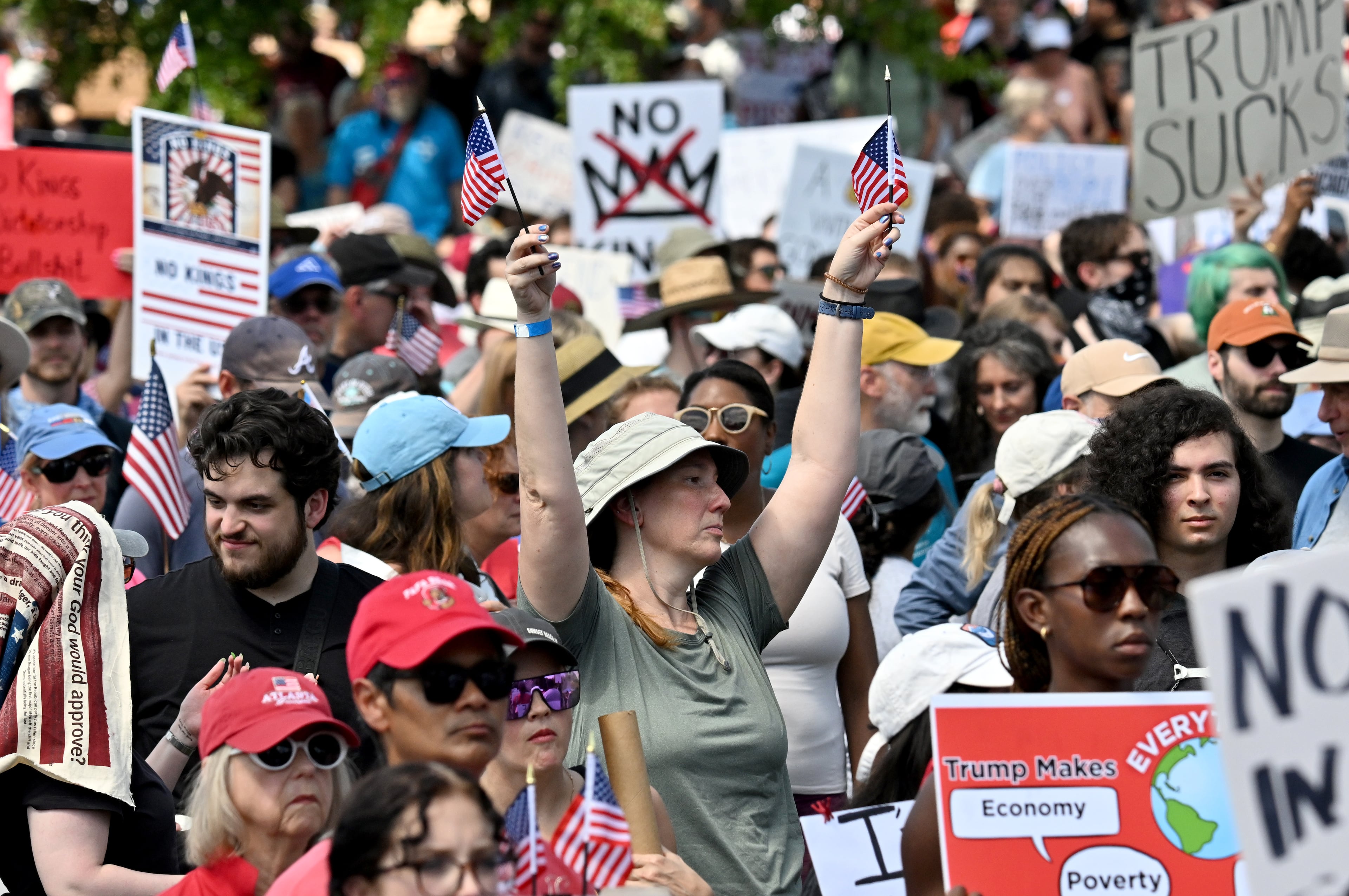 Demonstrators hold signs at Liberty Plaza, near the Georgia Capitol, for a "No Kings" protest to oppose Trump’s immigration policies, Saturday, June 14, 2025, in Atlanta. (Hyosub Shin / AJC)