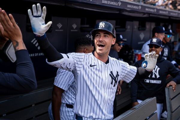 New York Yankees' Cody Bellinger (35) celebrates in the dugout after hitting a home run during the first inning of a baseball game against the Milwaukee Brewers, Saturday, March 29, 2025, in New York. (AP Photo/Angelina Katsanis)