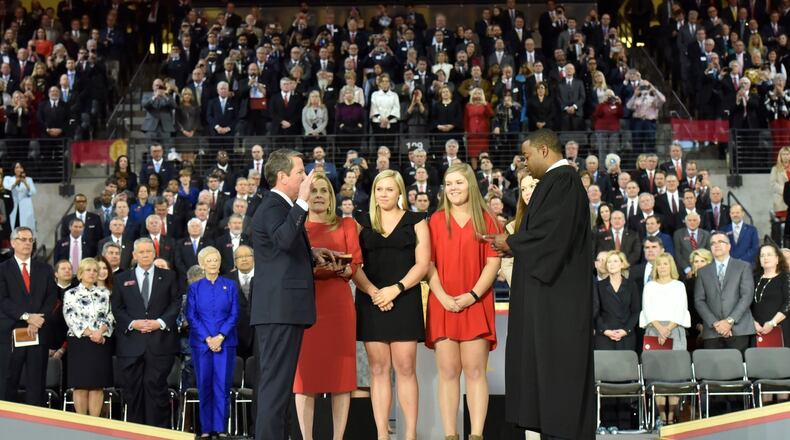 Brian Kemp takes the oath of office to become Georgia’s 83rd governor while his wife, Marty, holds the Bible and his daughers look on. Judge T.J. Hudson is administering the oath. Photo: Hyosub Shin / Hyosub.Shin@ajc.com