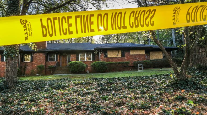 Crime tape surrounded an Oriole Drive home Mon., Apr. 4, 2016, two days after firefighters found a body severely burned in a pool Saturday. JOHN SPINK / JSPINK@AJC.COM