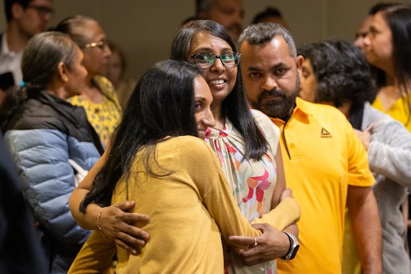 Family members of Mahendra Patel embrace in a Cobb County courtroom in Marietta after he is granted bond on Tuesday, May 6, 2025. Supporters wore yellow to the hearing. (Arvin Temkar/AJC)