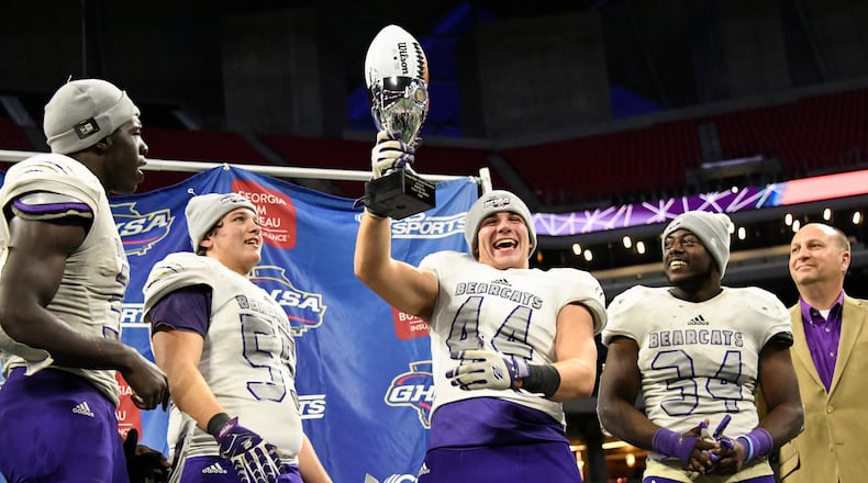 Bainbridge's Bowen Dodson lifts the trophy as from left, Roman Harrison, Jacob McLaughlin, and Randy Fillingame look on after their class 5A high school championship football game against Warner Robins, Tuesday, Dec., 11, 2018, at Mercedes-Benz Stadium, in Atlanta. Bainbridge won 47-41. (john Amis/Special)