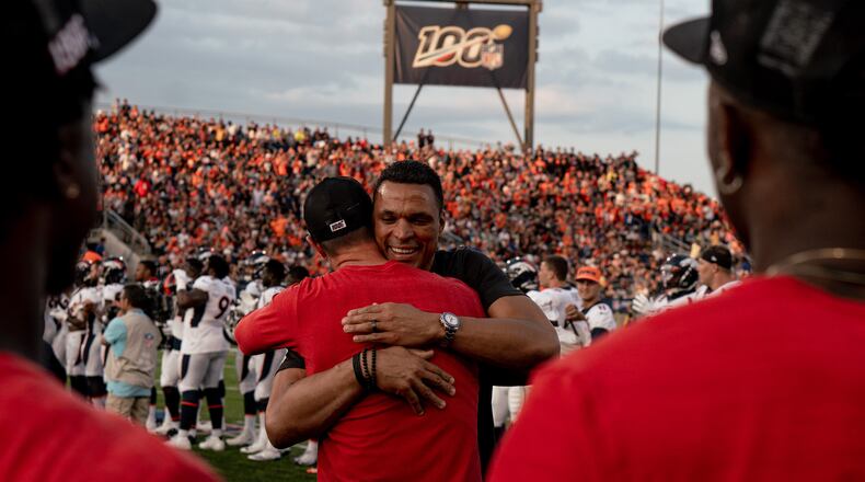 Hall of Famer Tony Gonzalez hugs Atlanta Falcons quarterback Matt Ryan (red) before the game against the Denver Broncos at Tom Benson Hall of Fame Stadium in Canton, Ohio, on Thursday August 1, 2019. (Photo by Kara Durrette/Atlanta Falcons)