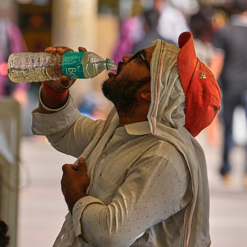 A commuter drinks water on a hot afternoon in New Delhi, India, Wednesday, May 20, 2026. (AP Photo/Manish Swarup)