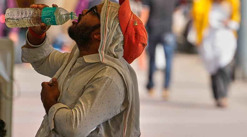 A commuter drinks water on a hot afternoon in New Delhi, India, Wednesday, May 20, 2026. (AP Photo/Manish Swarup)