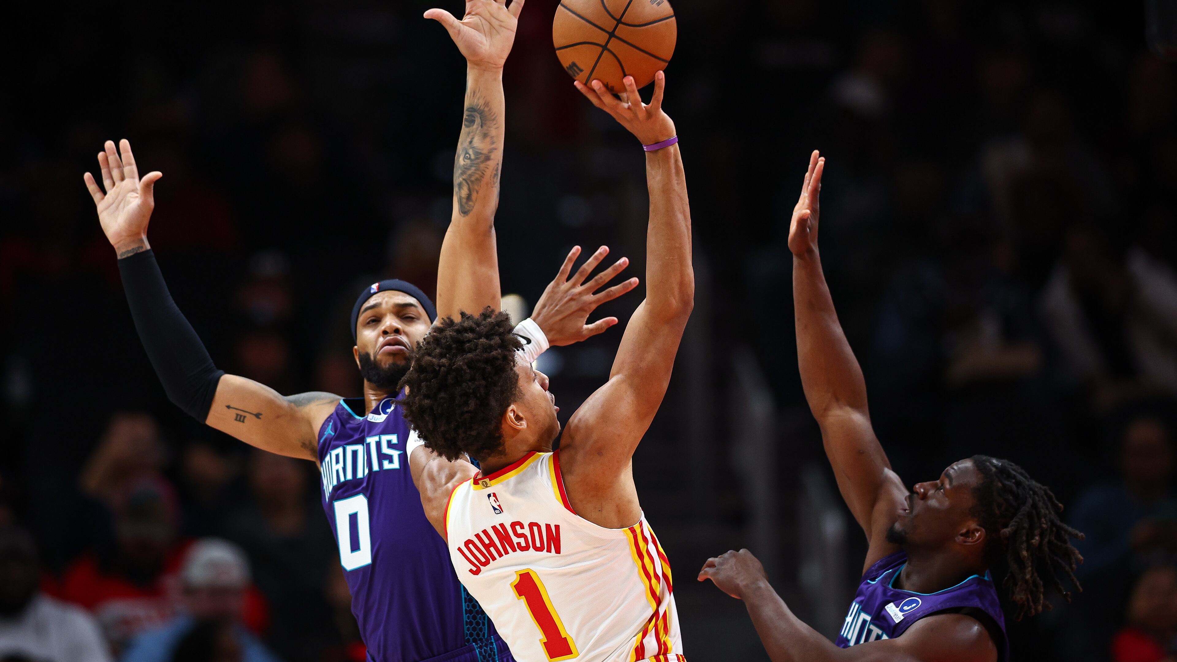 Atlanta Hawks forward Jalen Johnson (1) shoots against Charlotte Hornets forward Miles Bridges (0) and guard Sion James, right, during the first half of an NBA basketball game, Sunday, Nov. 23, 2025, in Atlanta. (AP Photo/Colin Hubbard)