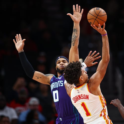 Atlanta Hawks forward Jalen Johnson (1) shoots against Charlotte Hornets forward Miles Bridges (0) and guard Sion James, right, during the first half of an NBA basketball game, Sunday, Nov. 23, 2025, in Atlanta. (AP Photo/Colin Hubbard)