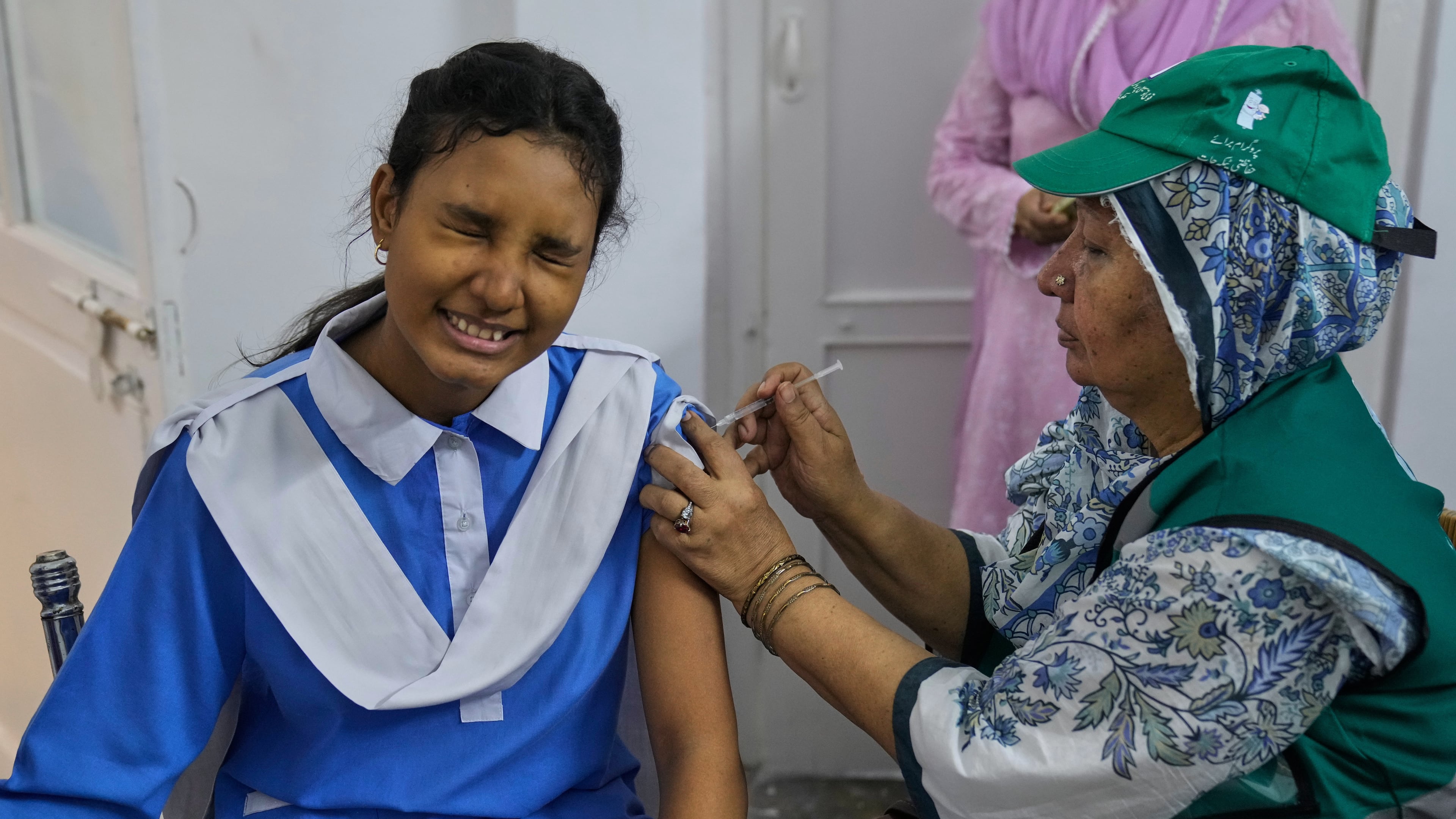 A health worker gives an injection of human papillomavirus (HPV) vaccine to a girl during a campaign aiming to protect girls from cervical cancer, at a school in Lahore, Pakistan, Monday, Sept. 22, 2025. (AP Photo/K.M. Chaudary)