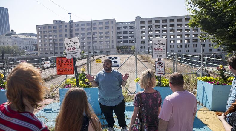 Actor Kevin Saunders, center, speaks with film buffs in front of the old Norfolk Southern building during an Atlanta Movie Tours trip to filming sights around downtown Atlanta. Saunders showed guests where an array of Hollywood superhero movies and television series were filmed in downtown Atlanta, including the Atlanta Marriott Marquis, the old Norfolk Southern building and Mitchell Street. (Alyssa Pointer/alyssa.pointer@ajc.com)