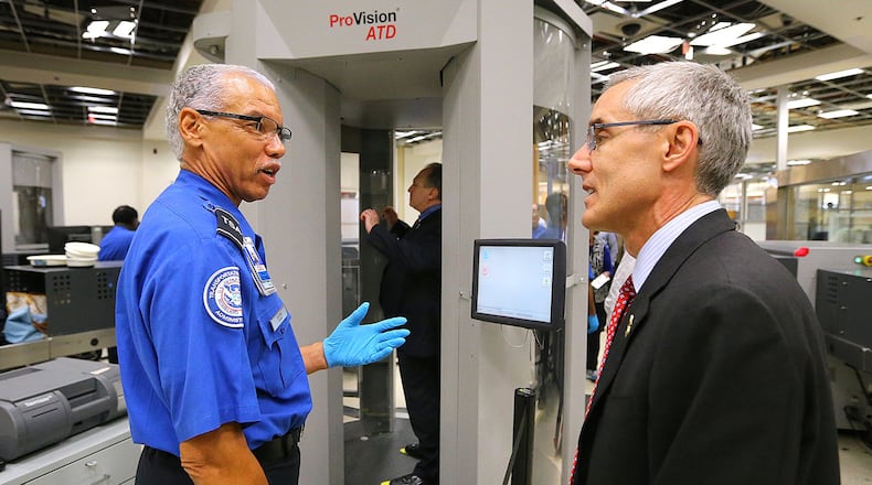 TSA Administrator Peter Neffenger, right, chats with TSA officer Garrison Brown as he passes through security after meeting with employees at Hartsfield-Jackson International Airport.