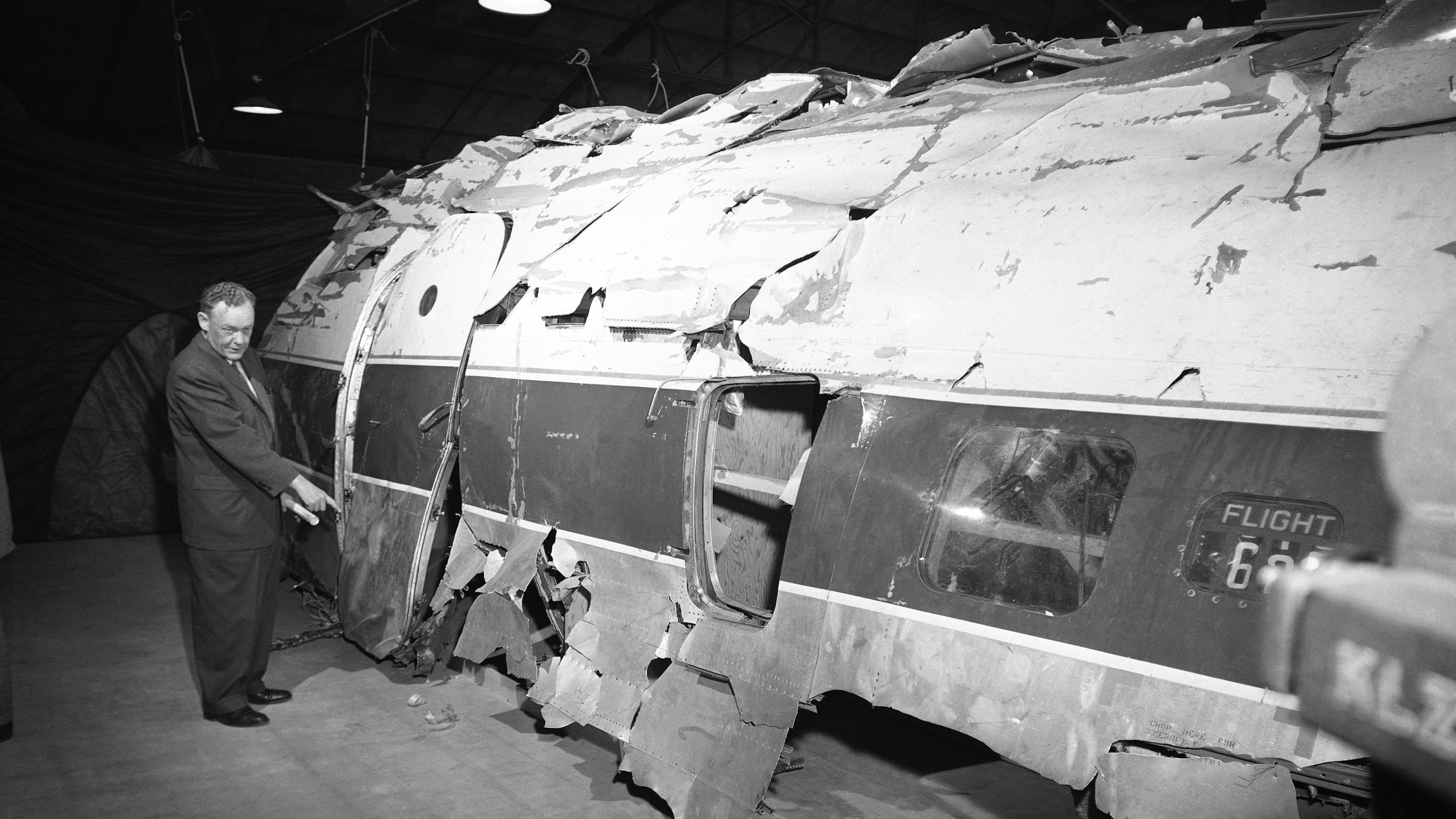 FILE - United Airlines official W.C. Mentzer stands in front of the United Airlines plane which John Gilbert Graham is accused of sabotaging with a dynamite-charged time bomb, after it was reconstructed, in Denver, Nov. 17, 1955. (AP Photo/Edward O. Eisenhand, File)