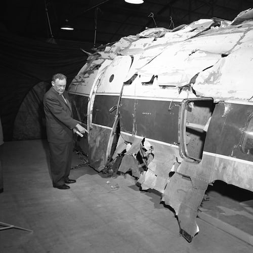 FILE - United Airlines official W.C. Mentzer stands in front of the United Airlines plane which John Gilbert Graham is accused of sabotaging with a dynamite-charged time bomb, after it was reconstructed, in Denver, Nov. 17, 1955. (AP Photo/Edward O. Eisenhand, File)