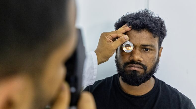 An eye care professional from VisionSpring examines a worker at a garment factory in Gazipur, on the outskirts of Dhaka, Bangladesh, June 30, 2026. (AP Photo/Rajib Dhar)