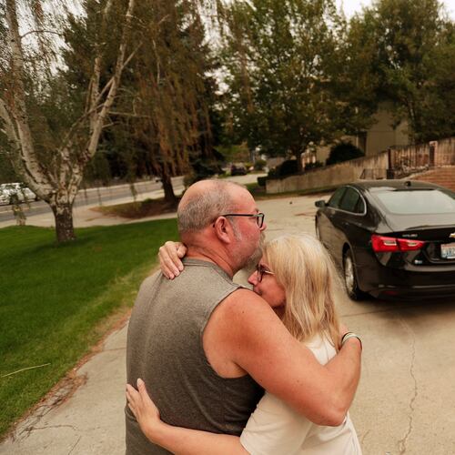 Allen Sather and his wife Kimberley embrace at the duplex they rent on W. Indian Trail Rd. after it burned in a wildfire in Spokane, Wash., Sunday, Aug. 2, 2026. (AP Photo/Young Kwak)