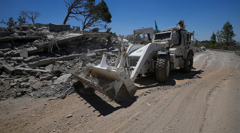 A bulldozer for the Spanish U.N peacekeeper opens a road in front of a house that was destroyed in the recent clashes between Hezbollah fighters and Israeli troops in Dibbine village, southeast Lebanon, Friday, June 5, 2026, a day after Israeli forces withdrew. (AP Photo/Hussein Malla)
