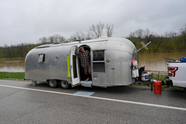 Michale Scott Memering looks out of his Airstream Travel Trailer after evacuating the Licking River RV Campground that was flooded by the rising waters of the Licking River, seen behind, Sunday, April 6, 2025, in Falmouth, Ky. (AP Photo/Carolyn Kaster)