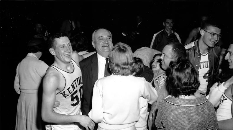 Kentucky basketball coach Adolph Rupp and guard Ad Smith (50) face fans and cheerleaders after Kentucky won their fourth NCAA championship over Seattle in Louisville, Ky., on March 22, 1958. (AP Photo/File)