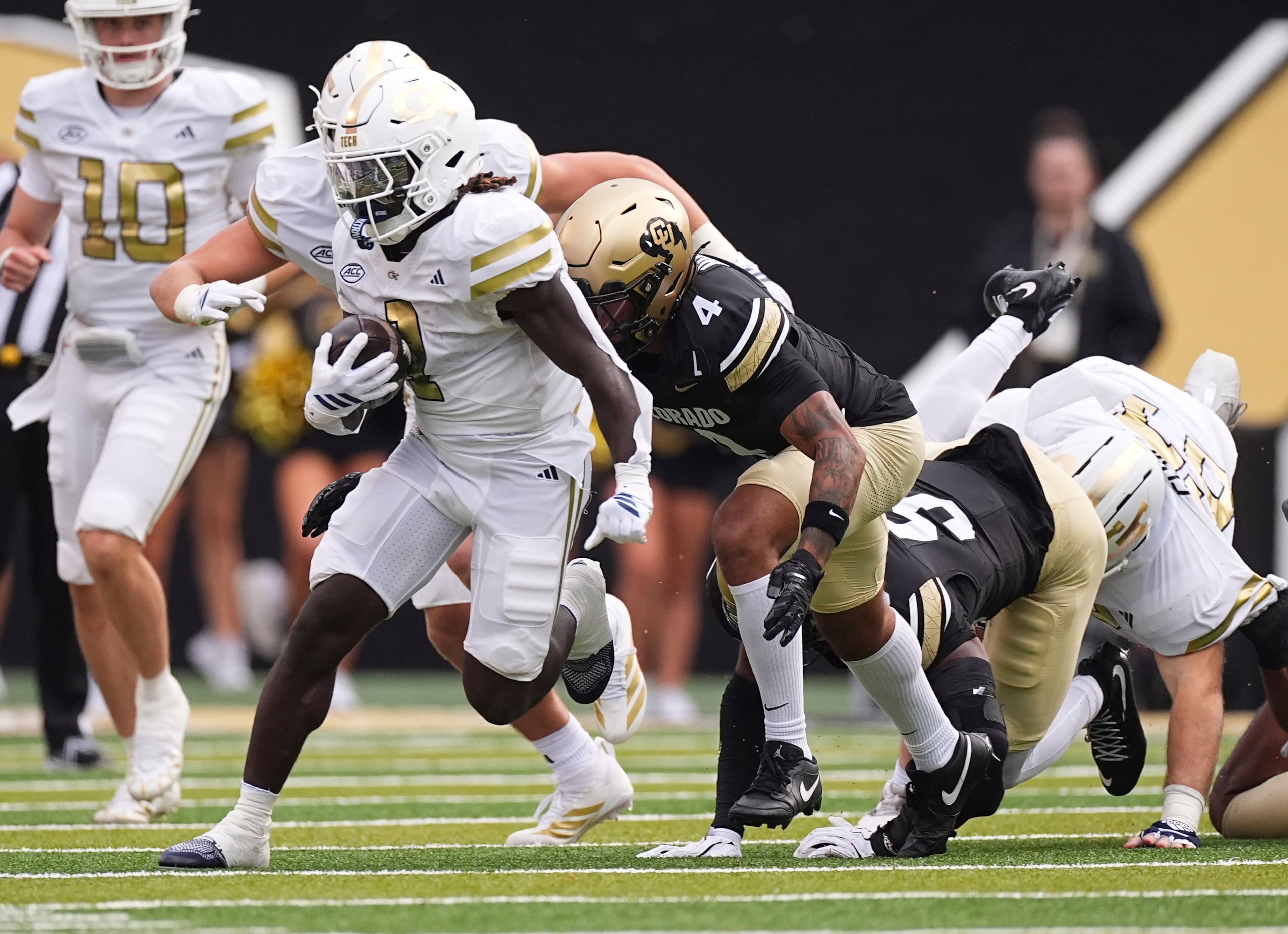 Georgia Tech running back Jamal Haynes, left, runs for a long gain past Colorado cornerback Preston Hodge, center, and linebacker Reginald Hughes in the first half of an NCAA college football game Friday, Aug. 29, 2025, in Boulder, Colo. (AP Photo/David Zalubowski)