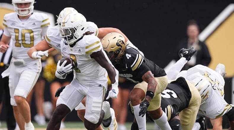 Georgia Tech running back Jamal Haynes (left) runs for a long gain past Colorado's Preston Hodge (center) and Reginald Hughes in August 2025 in Boulder, Colo. The Yellow Jackets won 27-20. (David Zalubowski/AP)