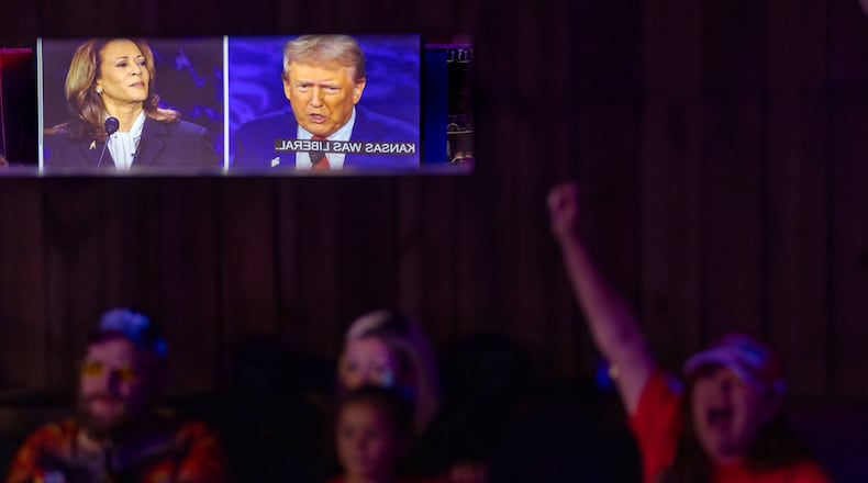 Tiana Robinson cheers at a Republican presidential debate watch party Tuesday at the Adventure Outdoors gun store and indoor shooting range in Smyrna. (Arvin Temkar / AJC)
