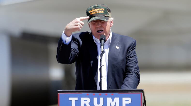 Republican presidential candidate Donald Trump gestures to a his camouflaged "Make America Great" hat as he discuses his support by the National Rifle Association at a campaign rally at the Redding Municipal Airport Friday, June 3, 2016, in Redding, Calif. (AP Photo/Rich Pedroncelli)