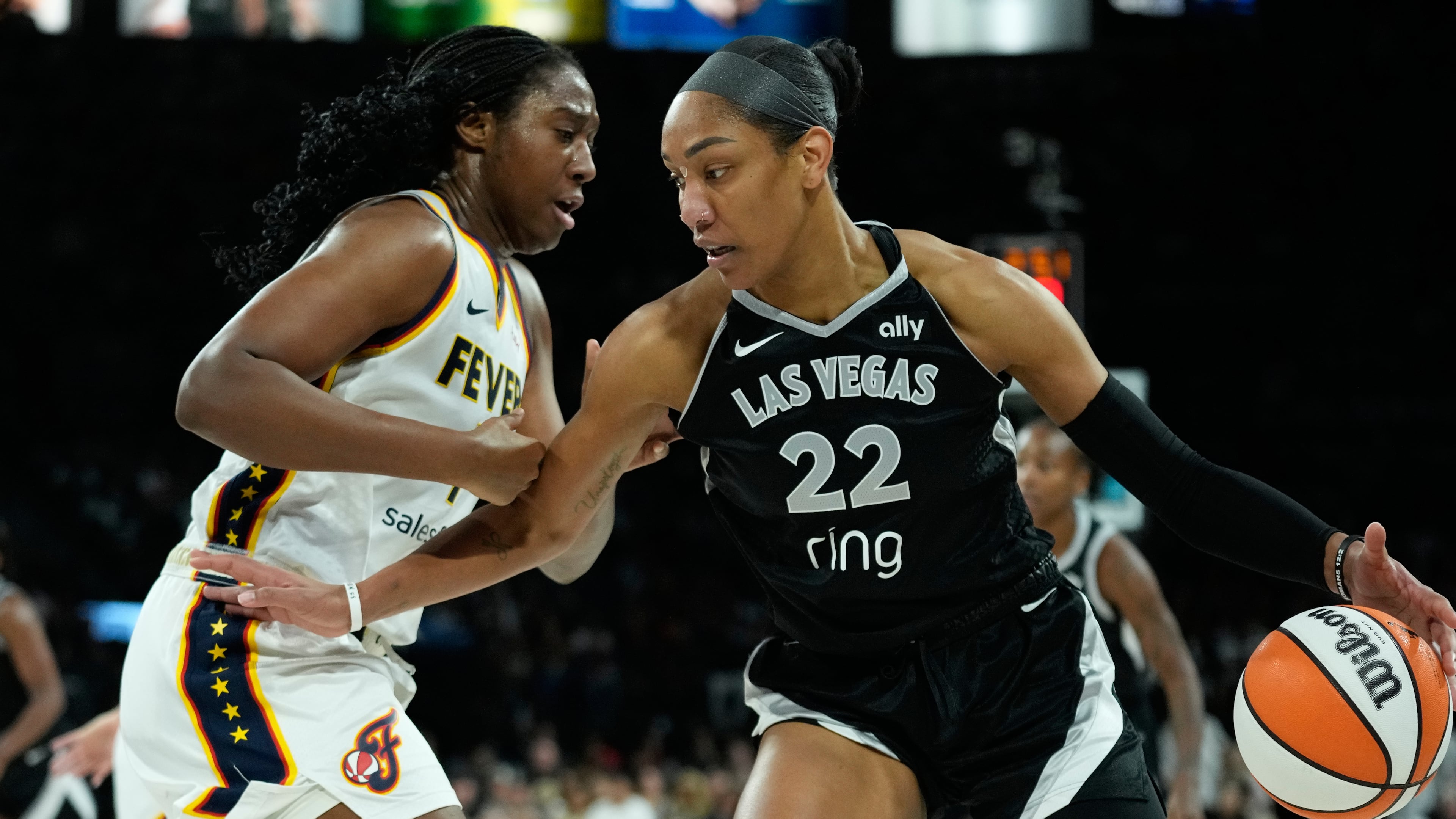 Las Vegas Aces center A'ja Wilson (22) drives against Indiana Fever forward Aliyah Boston (7) during the first half of Game 5 of a WNBA basketball playoff semifinals series Tuesday, Sept. 30, 2025, in Las Vegas. (AP Photo/John Locher)