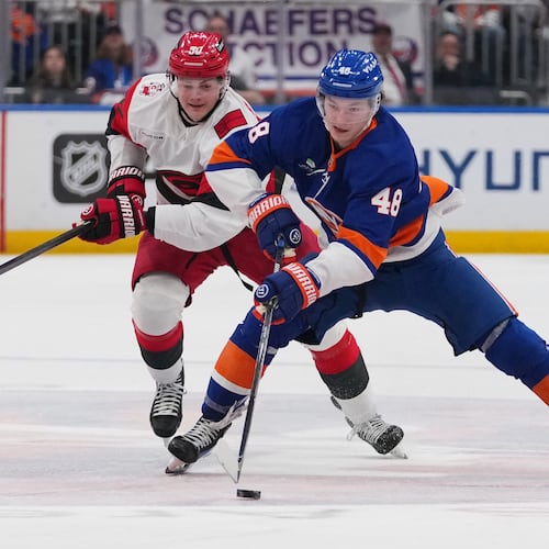 New York Islanders' Matthew Schaefer (48) drives past Carolina Hurricanes' Eric Robinson (50) during the second period of an NHL hockey game Tuesday, April 14, 2026, in Elmont, N.Y. (AP Photo/Frank Franklin II)
