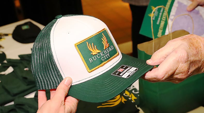 012422 Buckhead: Supporter Bob Prather (right) buys a Buckhead City hat from Tiffani Wittwer as he arrives for a Buckhead cityhood movement fundraiser on Monday, Jan. 24, 2022, in Buckhead. The Buckhead cityhood organization is starting a political action committee with $1 million in the bank, Buckhead City Committee chief executive Bill White told several hundred donors at Bistro Niko. “Curtis Compton / Curtis.Compton@ajc.com”`