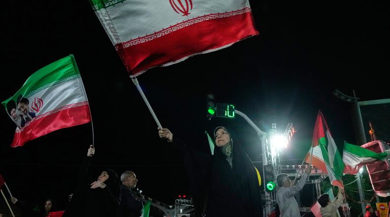 Pro-government demonstrators wave Iranian flags during a gathering in Tehran, Iran, Monday, April 27, 2026. (AP Photo/Vahid Salemi)