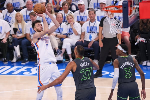 Oklahoma City Thunder forward Chet Holmgren (7) shoots in front of Minnesota Timberwolves center Rudy Gobert (27) and forward Jaden McDaniels (3) during the first half of Game 1 of an NBA basketball Western Conference Finals playoff series Tuesday, May 20, 2025, in Oklahoma City. (AP Photo/Nate Billings)