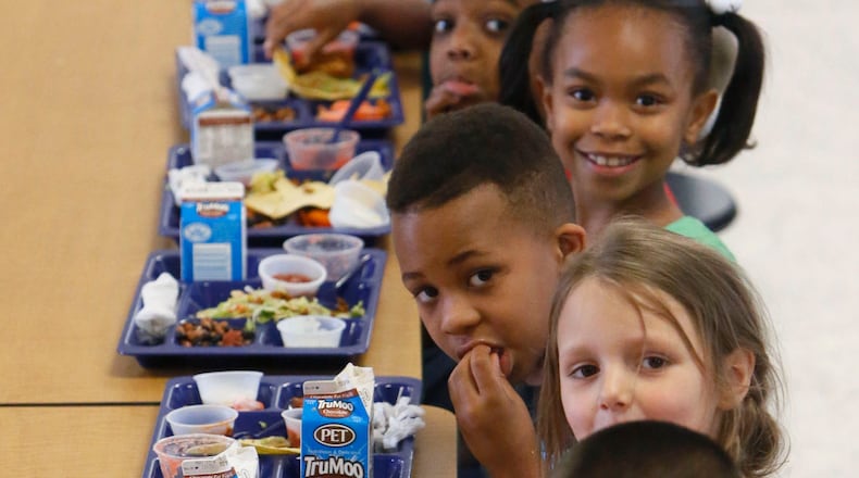 Kids at an elementary school in Augusta dig into lunch in May 2014. BOB ANDRES / BANDRES@AJC.COM
