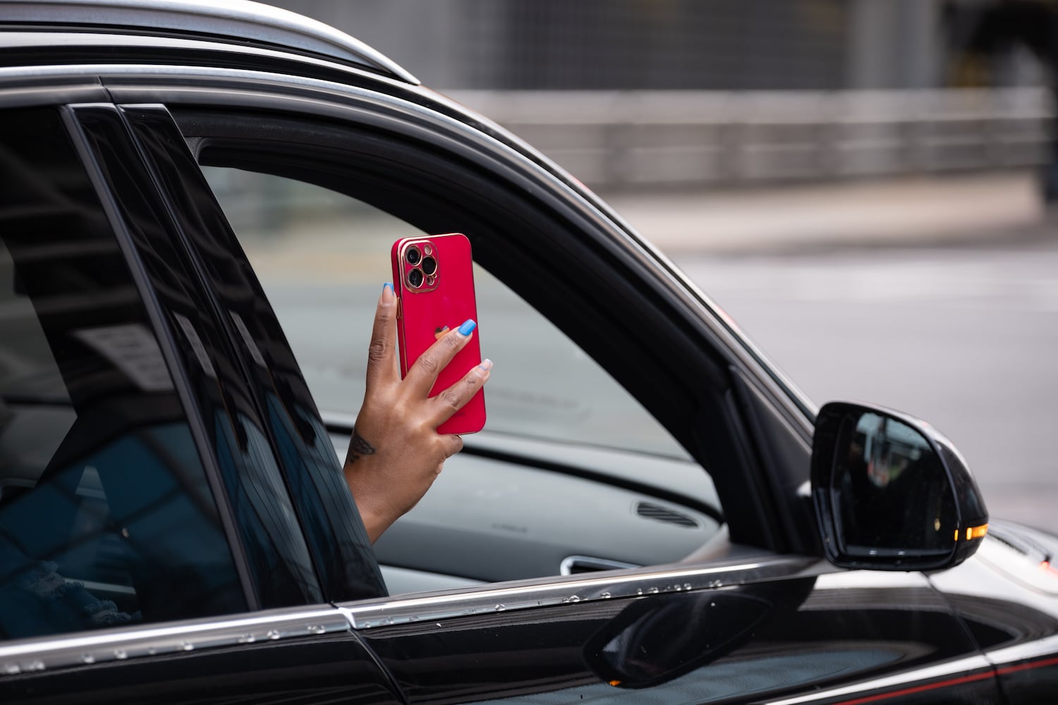 A person driving by records a protest in Atlanta on Saturday, Jan. 3, 2026, against the U.S. military action in Venezuela. (Ben Gray for the AJC)