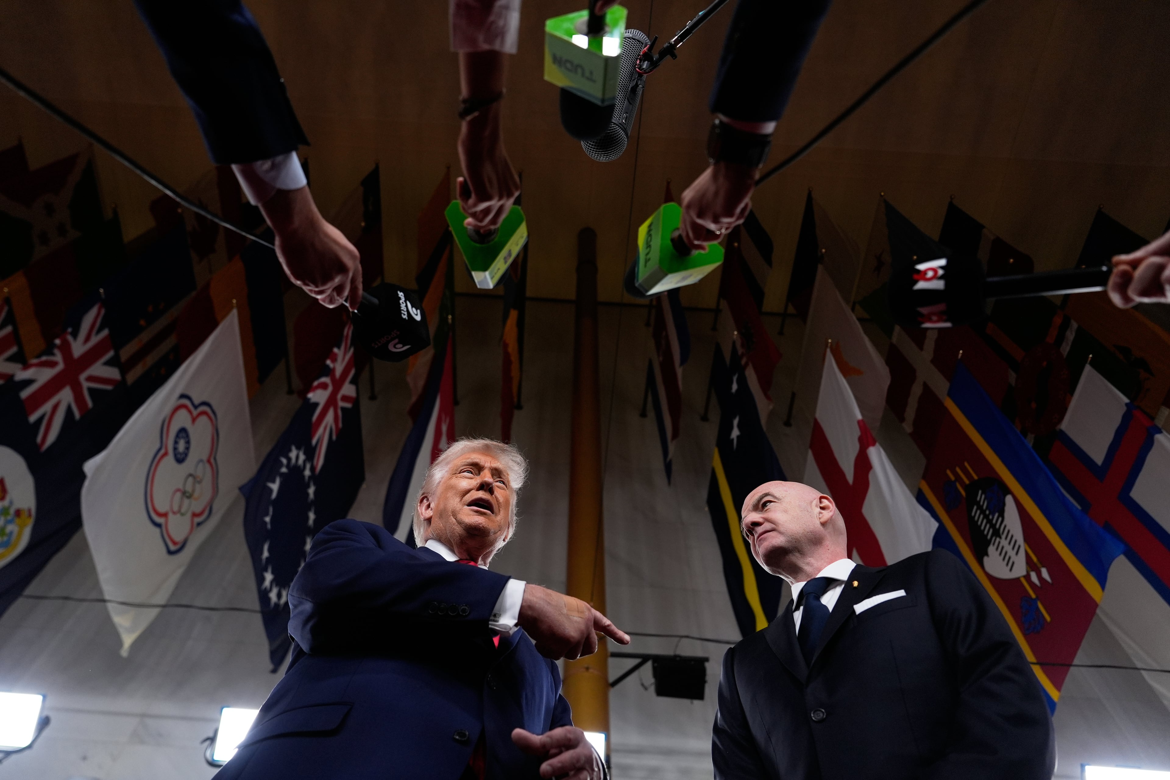 President Donald Trump speaks to reporters, next to FIFA President Gianni Infantino, as he arrives to attend the draw for the 2026 soccer World Cup at the Kennedy Center in Washington, Friday, Dec. 5, 2025. (AP Photo/Julia Demaree Nikhinson)