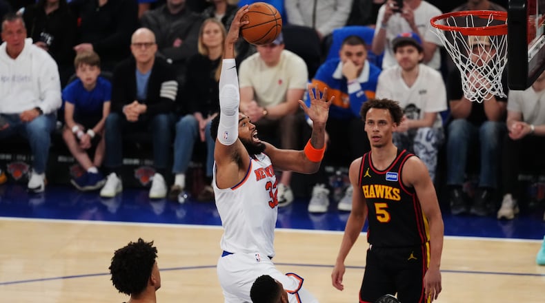 New York Knicks' Karl-Anthony Towns (32) drives past Atlanta Hawks' Dyson Daniels (5) during the first half in Game 1 of a first-round NBA playoffs basketball series, Saturday, April 18, 2026, in New York. (AP Photo/Frank Franklin II)