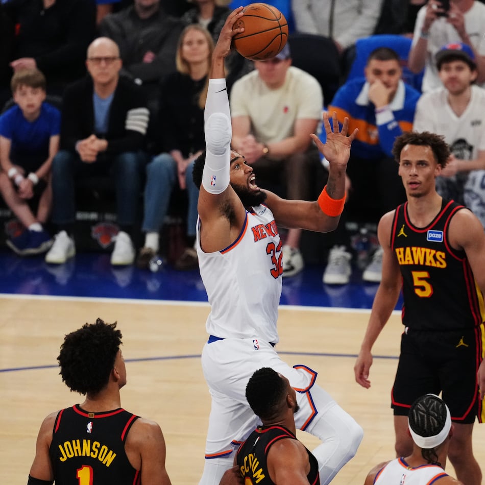 New York Knicks' Karl-Anthony Towns (32) drives past Atlanta Hawks' Dyson Daniels (5) during the first half in Game 1 of a first-round NBA playoffs basketball series, Saturday, April 18, 2026, in New York. (AP Photo/Frank Franklin II)
