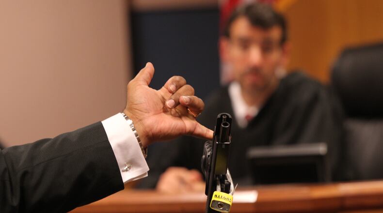 April 21, 2017, Atlanta, Georgia - Fulton assistant district attorney Clint Ruckers presents the handgun found at the home of Tex McIver to Judge Robert McBurney at a court appearance for prominent Atlanta attorney Tex McIver in Atlanta, Georgia. McIver may have his bond revoked after authorities conducting a search found a gun stored in a drawer full of socks at his home. (HENRY TAYLOR / HENRY.TAYLOR@AJC.COM)