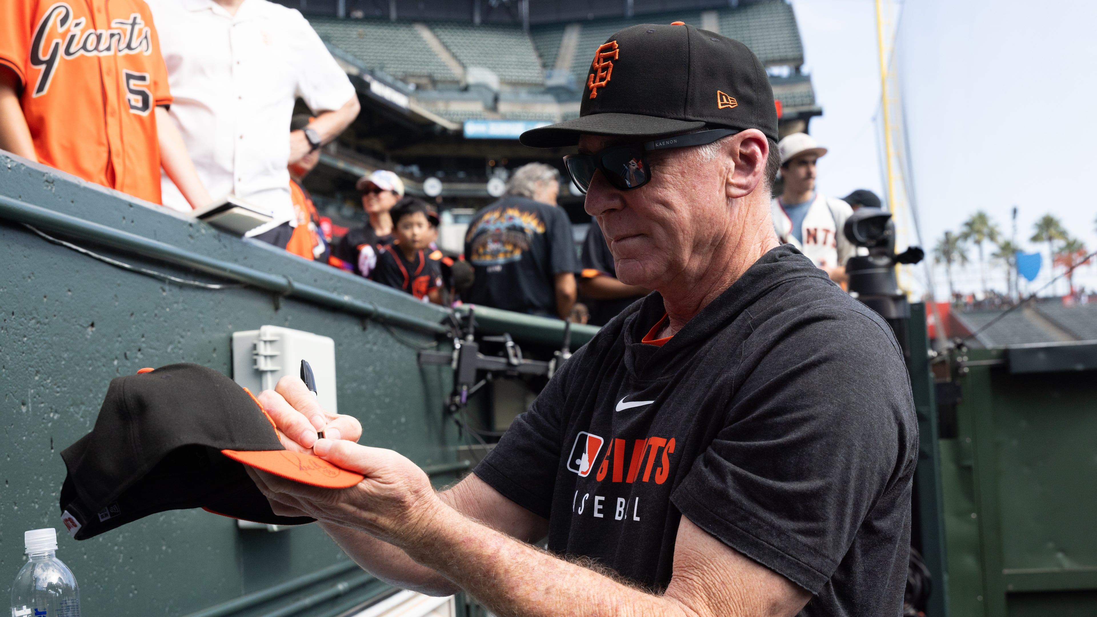 San Francisco Giants manager Bob Melvin gives out autographs before an MLB baseball game against the Colorado Rockies, Saturday, Sept. 27, 2025, in San Francisco. (AP Photo/Benjamin Fanjoy)