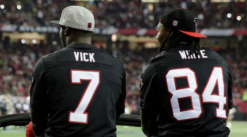 Former Atlanta Falcons players Roddy White, right, and Michael Vick are seen during halftime of game between the Atlanta Falcons and the New Orleans Saints, Sunday, Jan. 1, 2017, in Atlanta.
