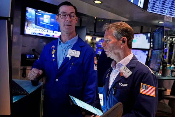 Specialist John McNierney. Left, and trader Robert Charmak work on the floor of the New York Stock Exchange, Wednesday, April 16, 2025. (AP Photo/Richard Drew)