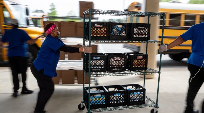 200407-Lilburn-Gwinnett County cafeteria workers bring freshly prepared food out to waiting school buses in front of Berkmar High School so they can be delivered to students around the district. Ben@BenGray.com for the Atlanta Journal-Constitution AJC FILE PHOTO