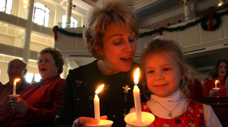 A youngster enjoys the candlelight service at Mt. Bethel United Methodist Church in Marietta. (Joey Ivansco / AJC File)