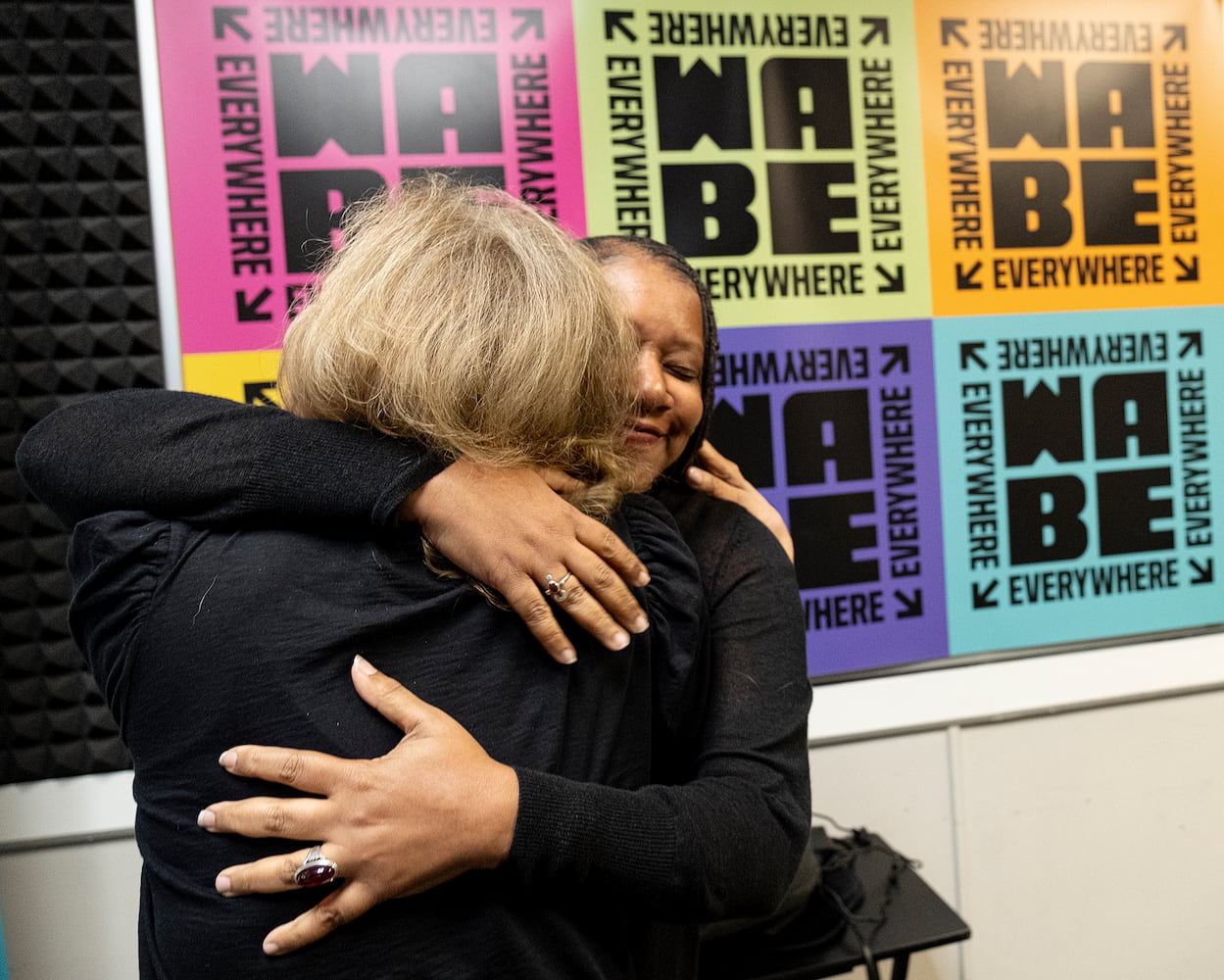 WABE’s Lois Reitzes, left, and Rose Scott embrace in the studio in Atlanta on Monday, Sept. 18, 2023.   (Ben Gray / Ben@BenGray.com)