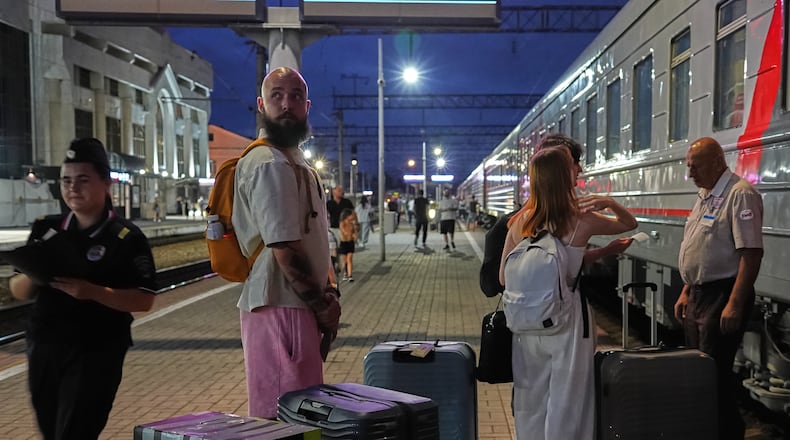 A 28-year-old digital content marketer who decided to leave Russia stands near his packed belongings at the railway station in Krasnodar, Russia, on Saturday, Aug. 29, 2026. He asked not to be identified because of security concerns. (AP Photo)