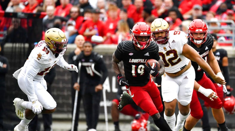 Louisville running back Hassan Hall (19) runs from the pursuit of Boston College linebacker Isaiah Graham-Mobley (19), and defensive lineman Izaiah Henderson (92) during the first half of an NCAA college football game in Louisville, Ky., Saturday, Oct. 23, 2021. (AP Photo/Timothy D. Easley)